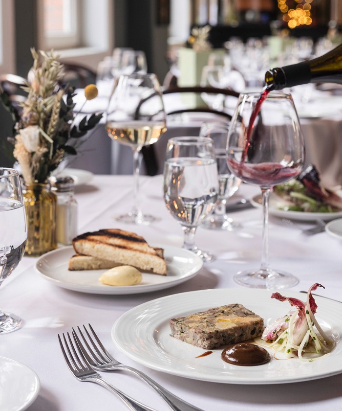 Red wine being poured at a wedding table